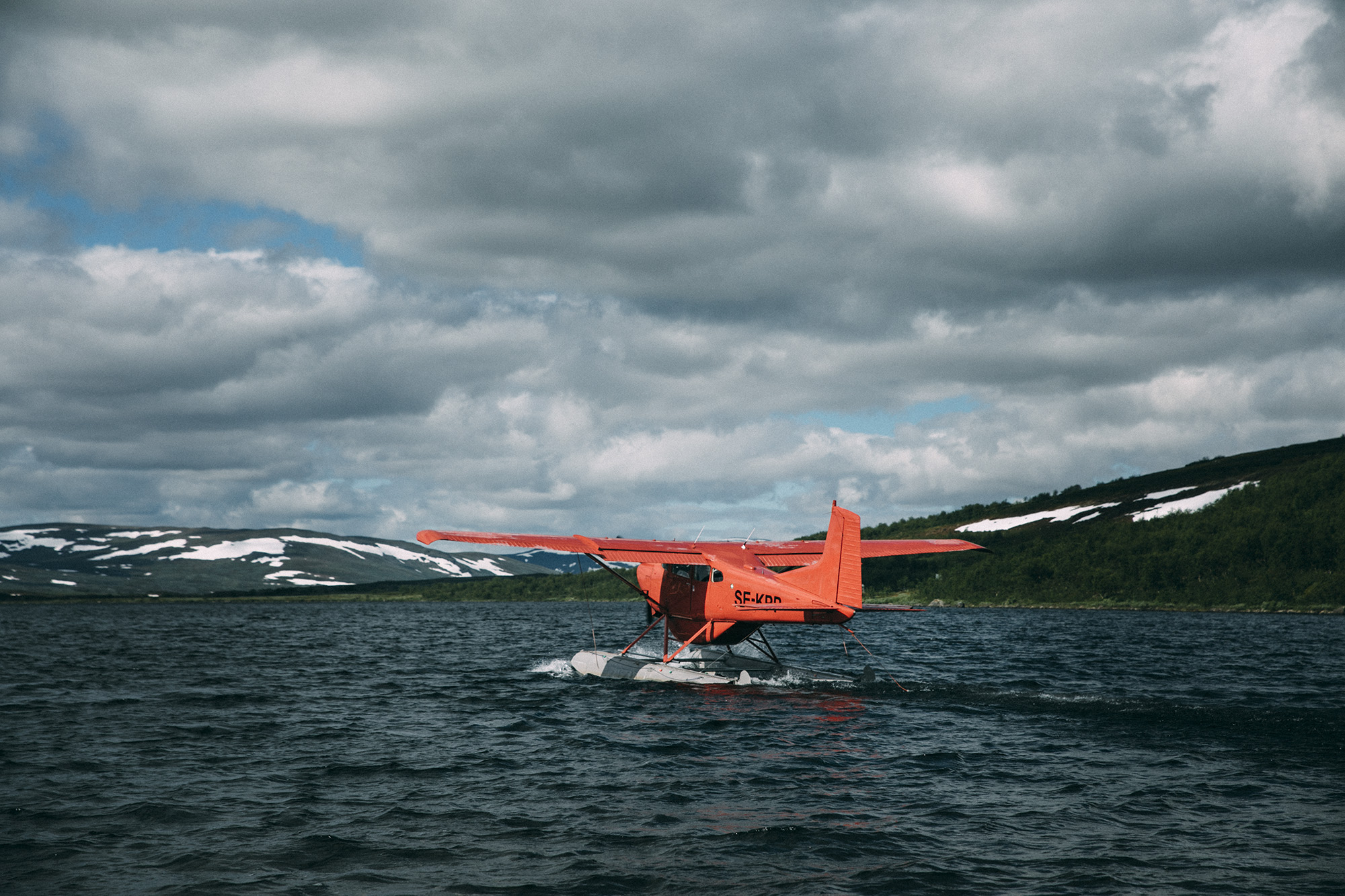 Red seaplane on northern water by Camp Gauto