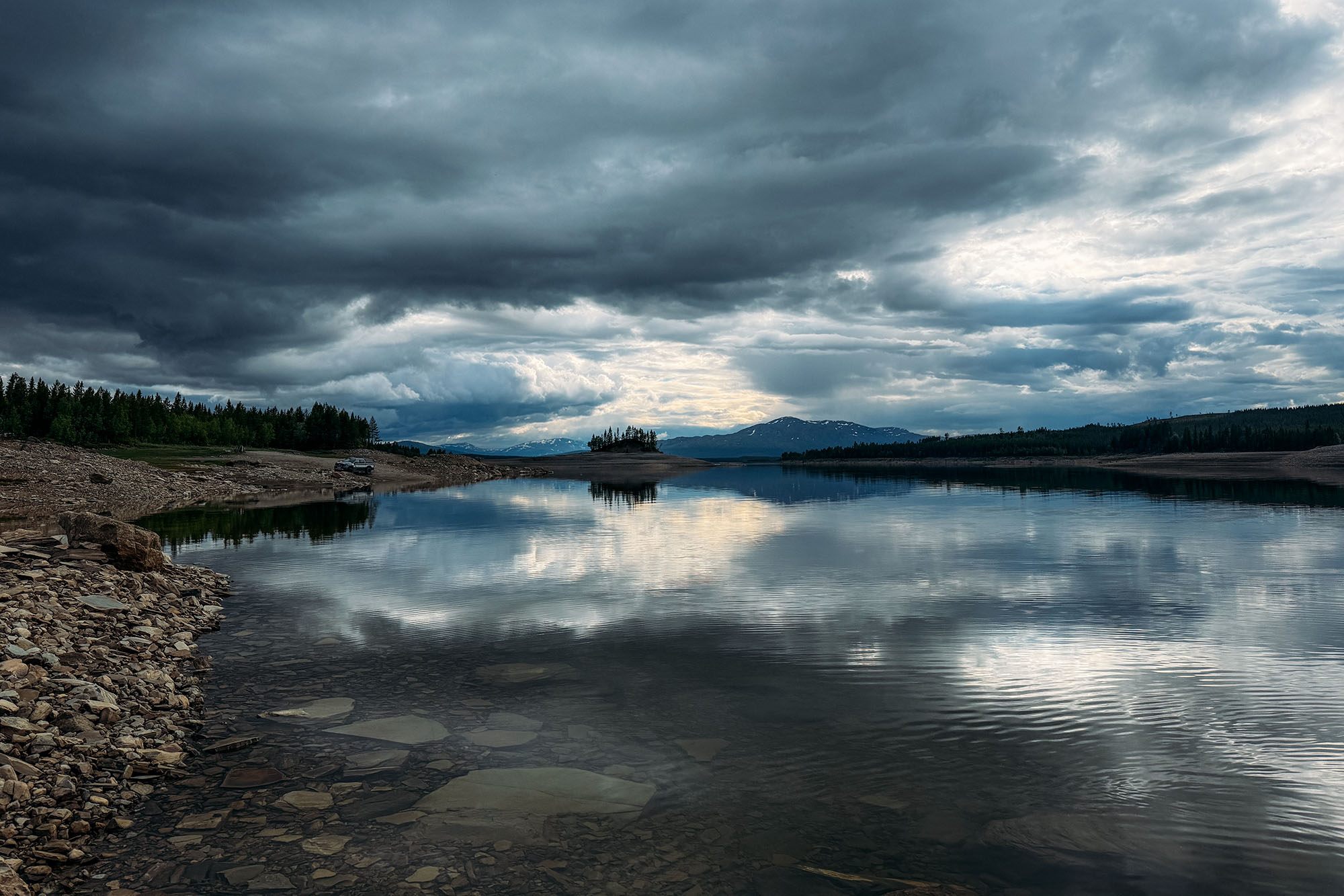 Lake and mountain landscape under dramatic sky